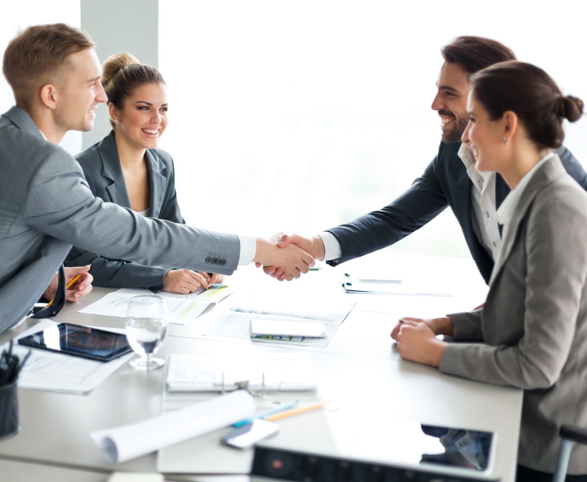 varias personas se dan la mano en una oficina