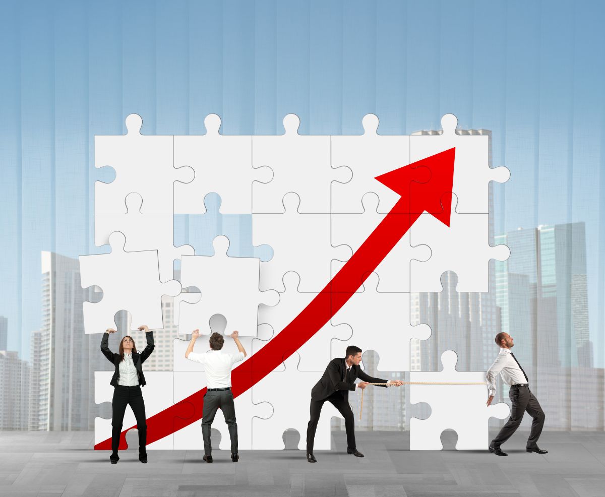 varias personas construyen un puzzle que representa una flecha ascendente